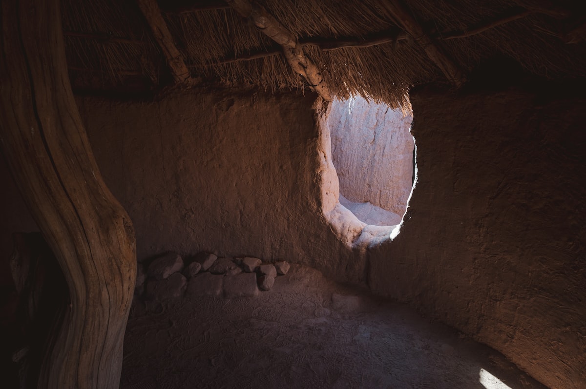 Interior of a rustic mud hut with natural light through a window