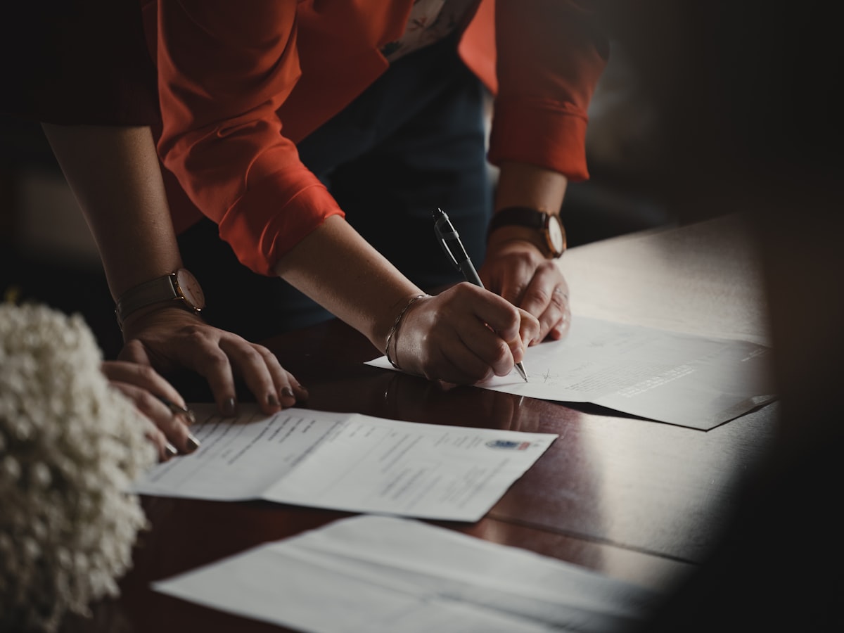 Person carefully filling out official legal forms