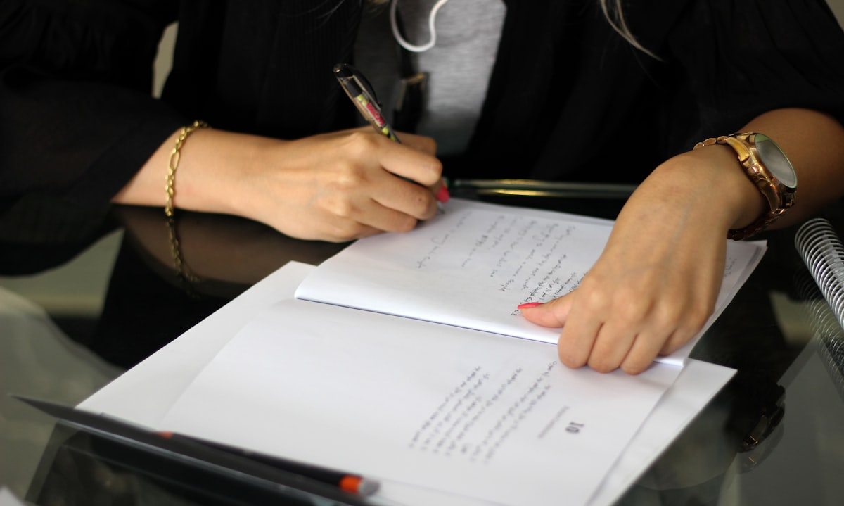Signing documents with a pen on official paper