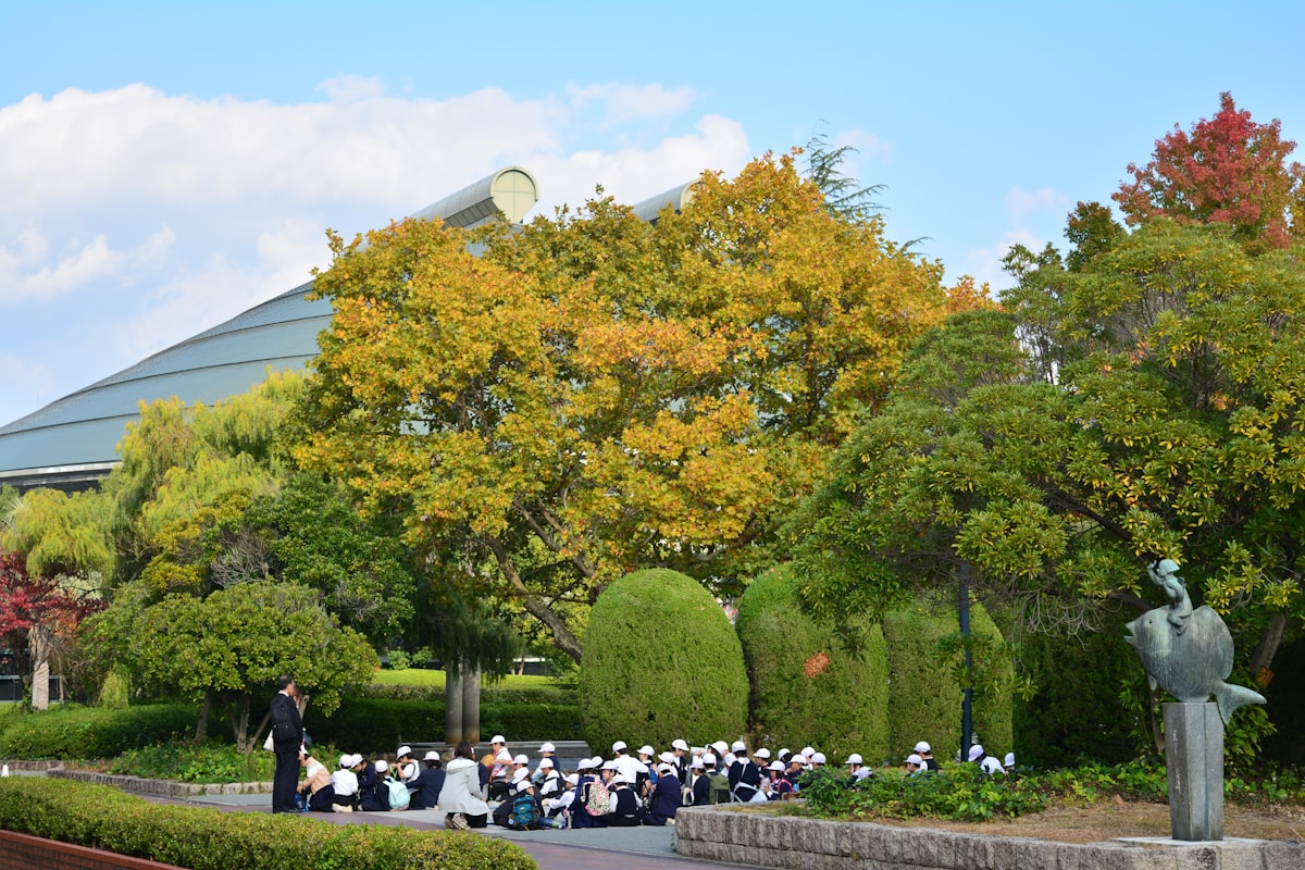 Group gathered outdoors near trees for a nature lesson