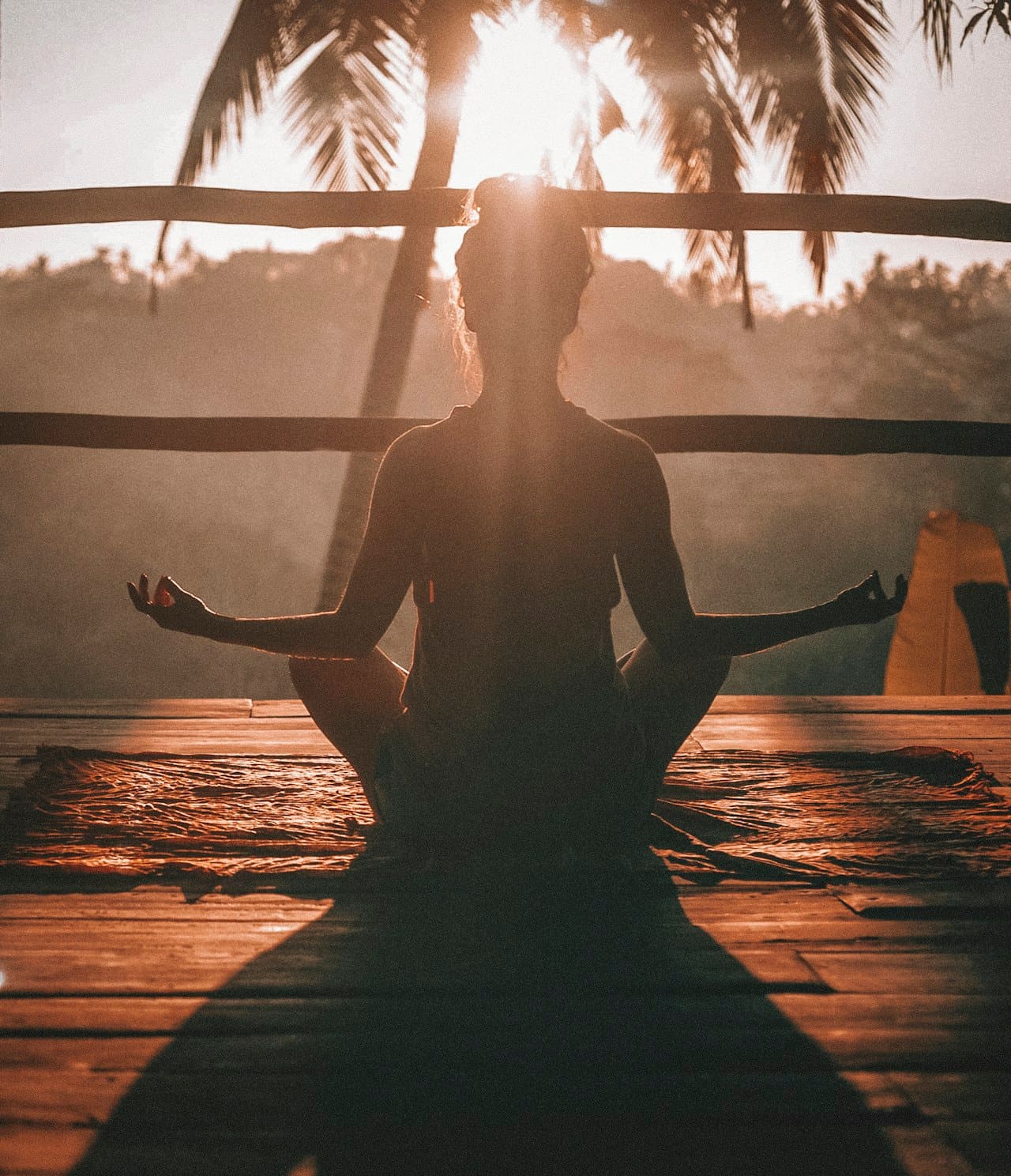 Yoga practice on a beach at sunrise, the Pacific Ocean reflecting the first light